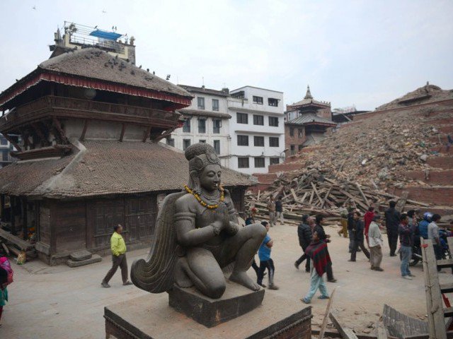 nepalese residents walk beside buildings severely damaged by an earthquake on kathmandu on april 26 2015 rescuers in nepal searched frantically for survivors of a quake that killed more than 2 000 digging through rubble in the devastated capital kathmandu and airlifting victims of an avalanche at everest base camp photo afp