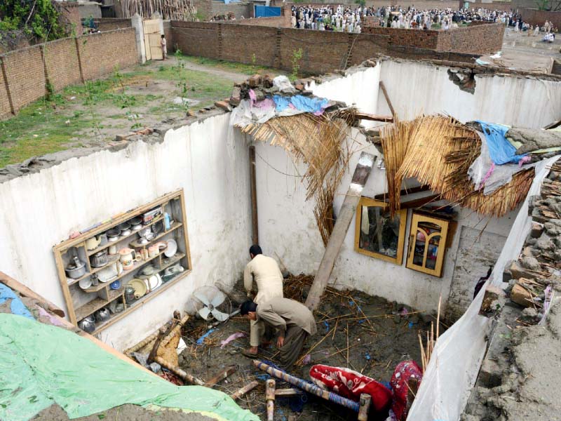 two men sift through the rubble of their home in peshawar photo afp