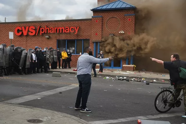 two men argue opposing views as a cvs pharmacy burns at the corner of pennsylvania and north avenues during violent protests following the funeral of freddie gray april 27 2015 in baltimore maryland photo afp two men argue opposing views as a cvs pharmacy burns at the corner of pennsylvania and north avenues during violent protests following the funeral of freddie gray april 27 2015 in baltimore maryland photo afp