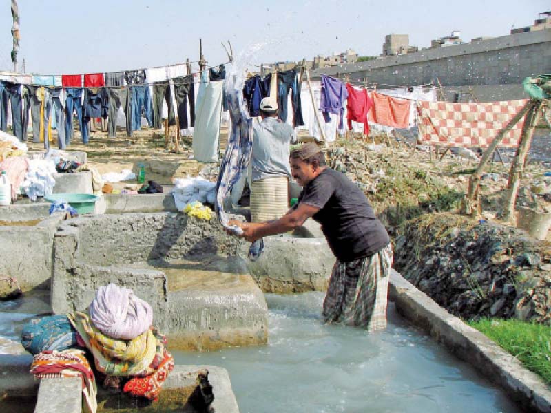 a dhobi washes clothes at the dhobi ghat situated under the teen hatti bridge photo file