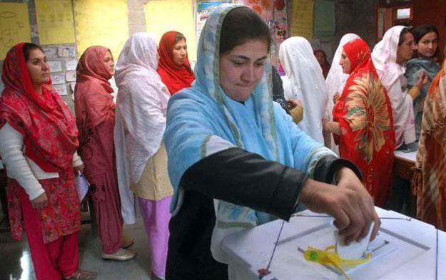 a voter casts her vote at a polling station during the first legislative assembly elections of gilgit baltistan photo app