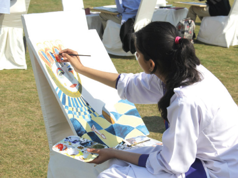 a student paints at a competition photo ayesha mir express