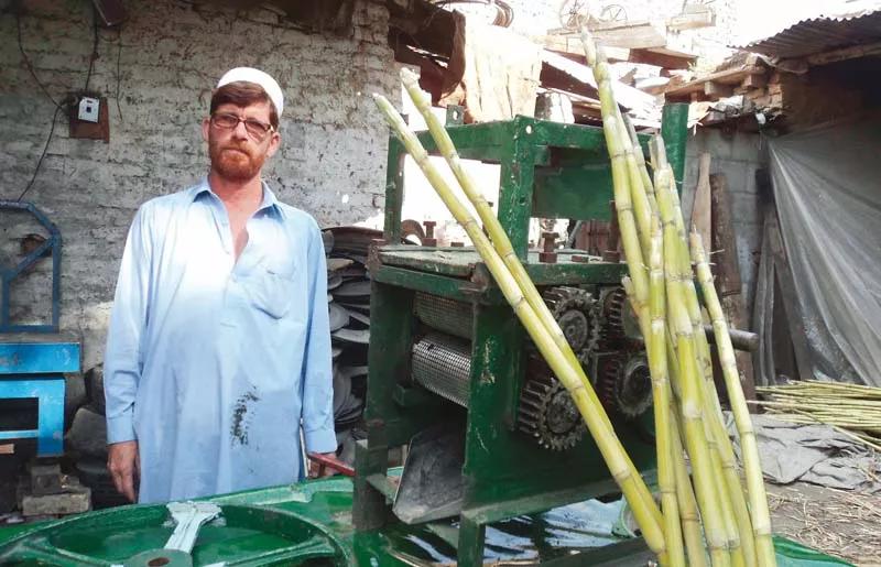roshan ali stands beside his sugarcane juice machine photo fazal khaliq express roshan ali stands beside his sugarcane juice machine photo fazal khaliq express