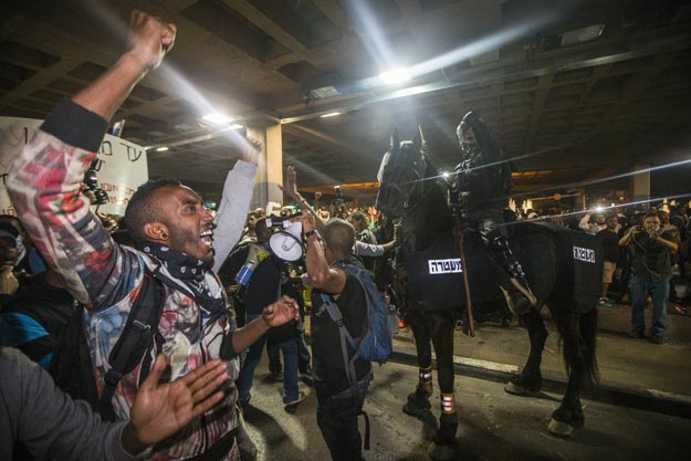 israelis from the ethiopian community shout slogans in front of israeli security forces in the coastal city of tel aviv on may 3 2015 during a protest against alleged police brutality and institutionalised discrimination photo afp