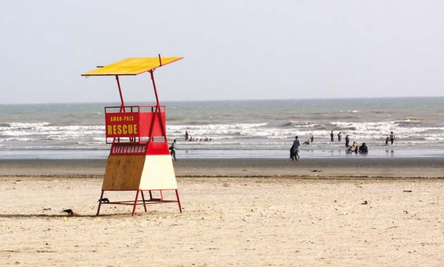 a watch tower stands empty at the beach at sea view while picnickers bathe in the water forty people drowned here last year photo athar khan express a watch tower stands empty at the beach at sea view while picnickers bathe in the water forty people drowned here last year photo athar khan express