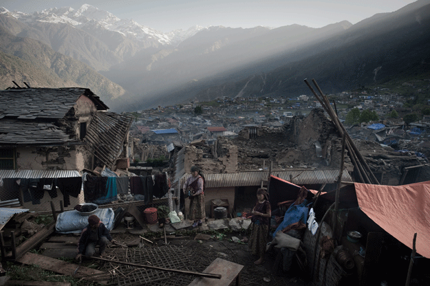 a villager constructing a makeshift tent for his family next to his destroyed house in the village of barpak in north central nepal nine days after a 7 8 magnitude earthquake struck the himalayan nation photo afp