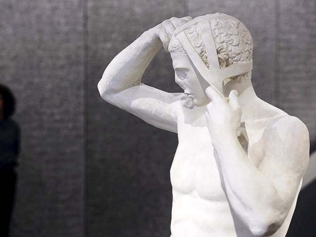 a woman stands near an artwork called head of the amelung type athlete at the prada foundation in milan photo reuters a woman stands near an artwork called head of the amelung type athlete at the prada foundation in milan photo reuters
