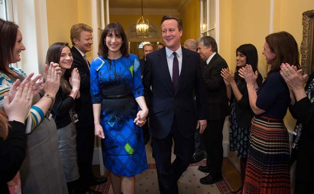 britain 039 s prime minister and leader of the conservative party david cameron and his wife samantha are applauded by staff upon entering 10 downing street in london on may 8 2015 after visiting queen elizabeth ii a day after the british general election photo afp