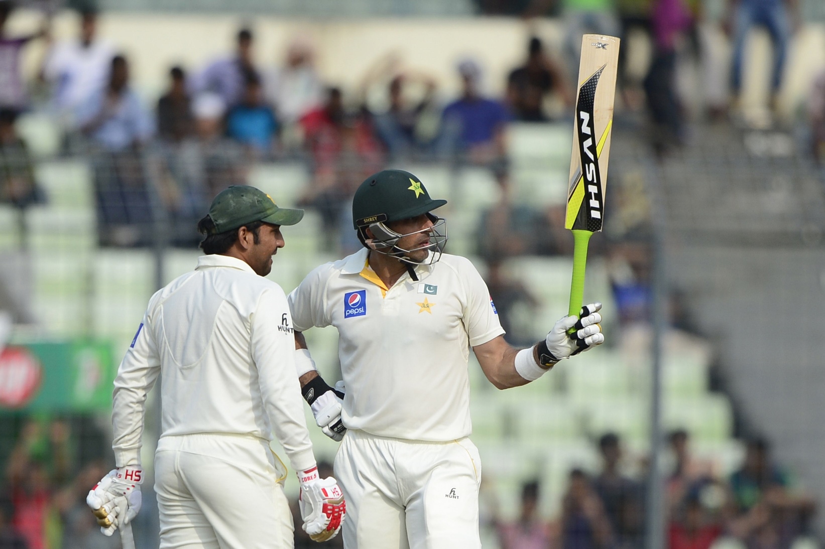 pakistan captain misbah ul haq r reacts after scoring a half century 50 runs as his teammate sarfraz ahmed looks on during the third day of the second cricket test match between bangladesh and pakistan at the sher e bangla national cricket stadium in dhaka on may 8 2015 photo afp