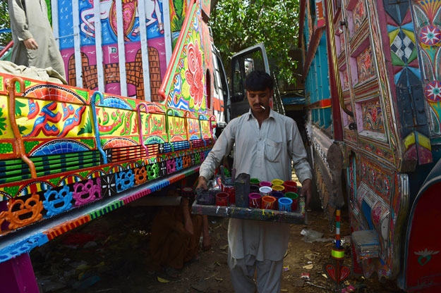 a painter prepares to finish decorating a truck at his workshop in rawalpindi photo afp