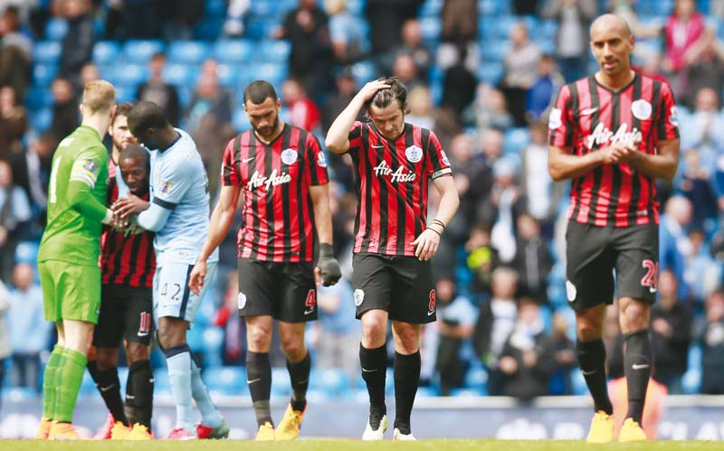 qpr players walk off dejectedly as a 6 0 thrashing at the hands of manchester city saw them sent back to the championship after only one year at the top photo afp