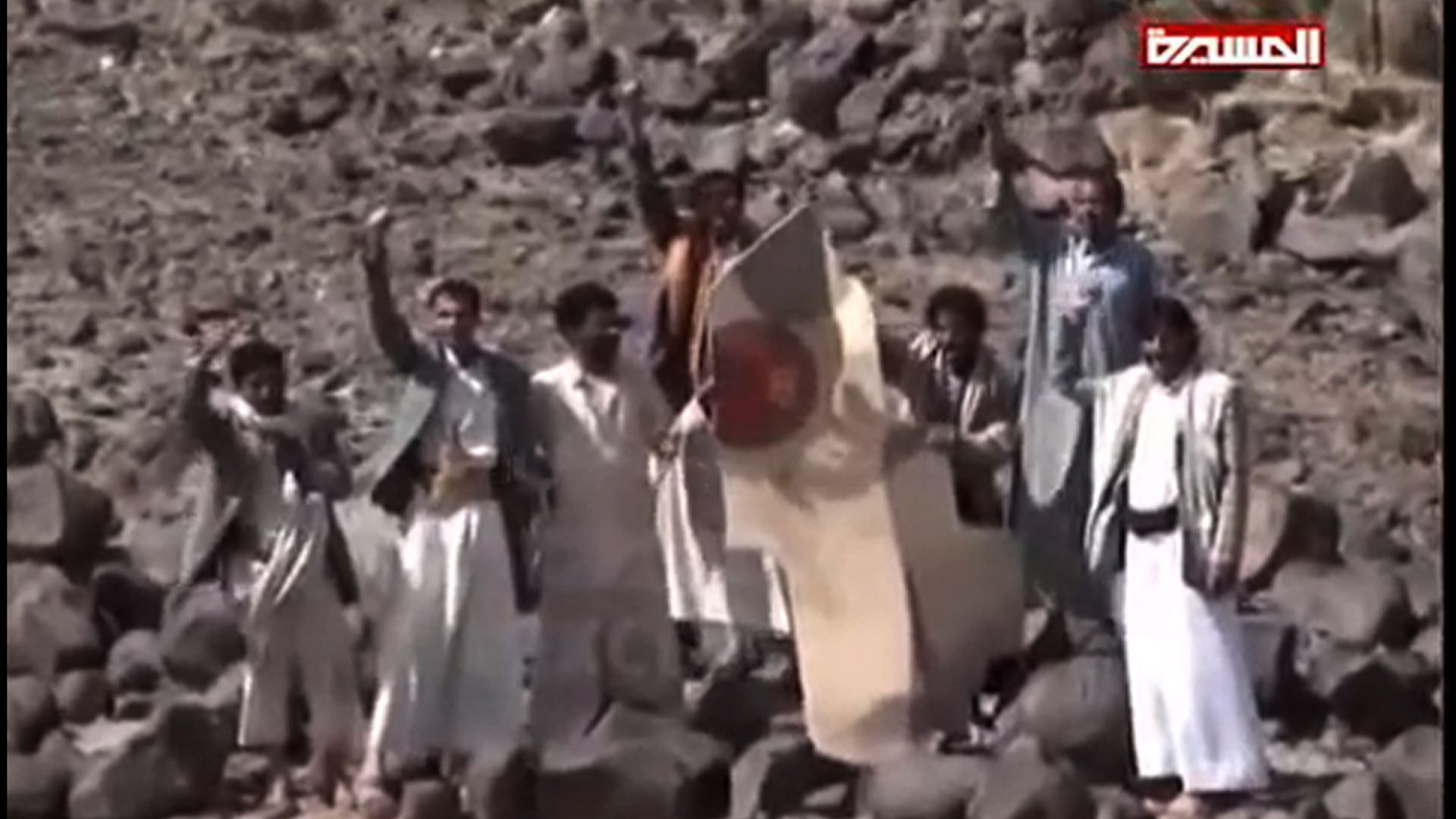 an image grab taken from the huthi rebel television station al masira shows yemeni tribesmen celebrating around the wreckage of a plane bearing a moroccan flag in the the wadi nushur area in the north yemen 039 s province of saada on may 11 2015 photo afp