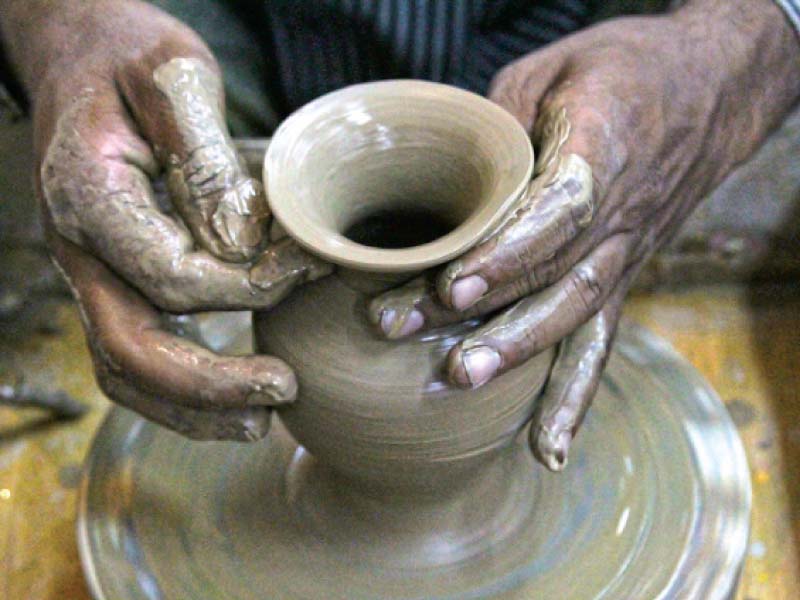an artisan carefully paints an intricate pattern onto a block of terracotta at a stall in the heritage fair held at the arts council karachi on sunday the fair aims to promote traditional craftsmanship photos aysha saleem express