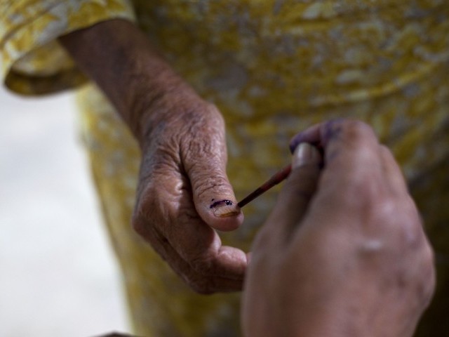 a voter getting her thumb inked photo express