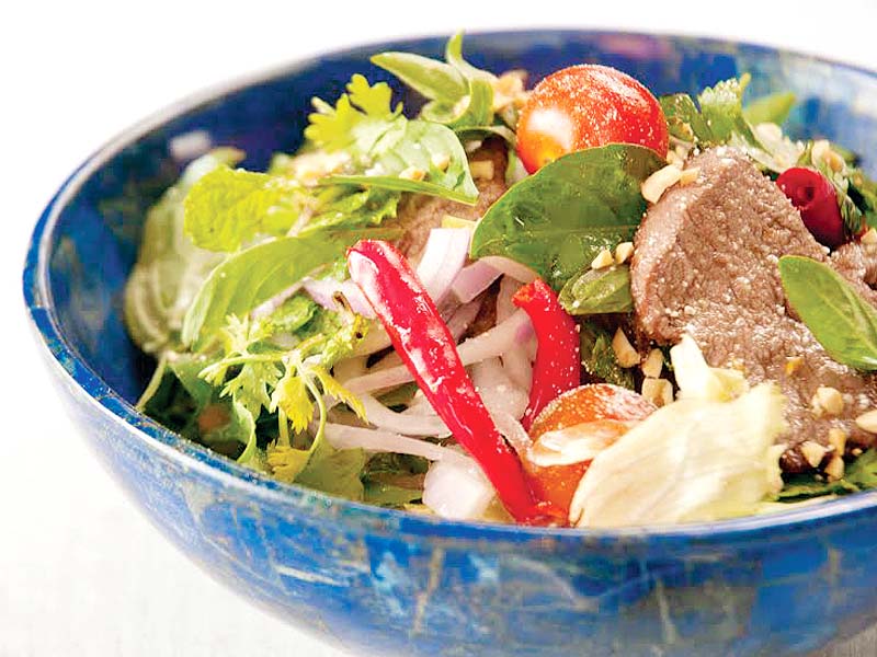 thai beef salad is juicy and succulent laden on a bed of rocket leaves with sesame seeds photo publicty