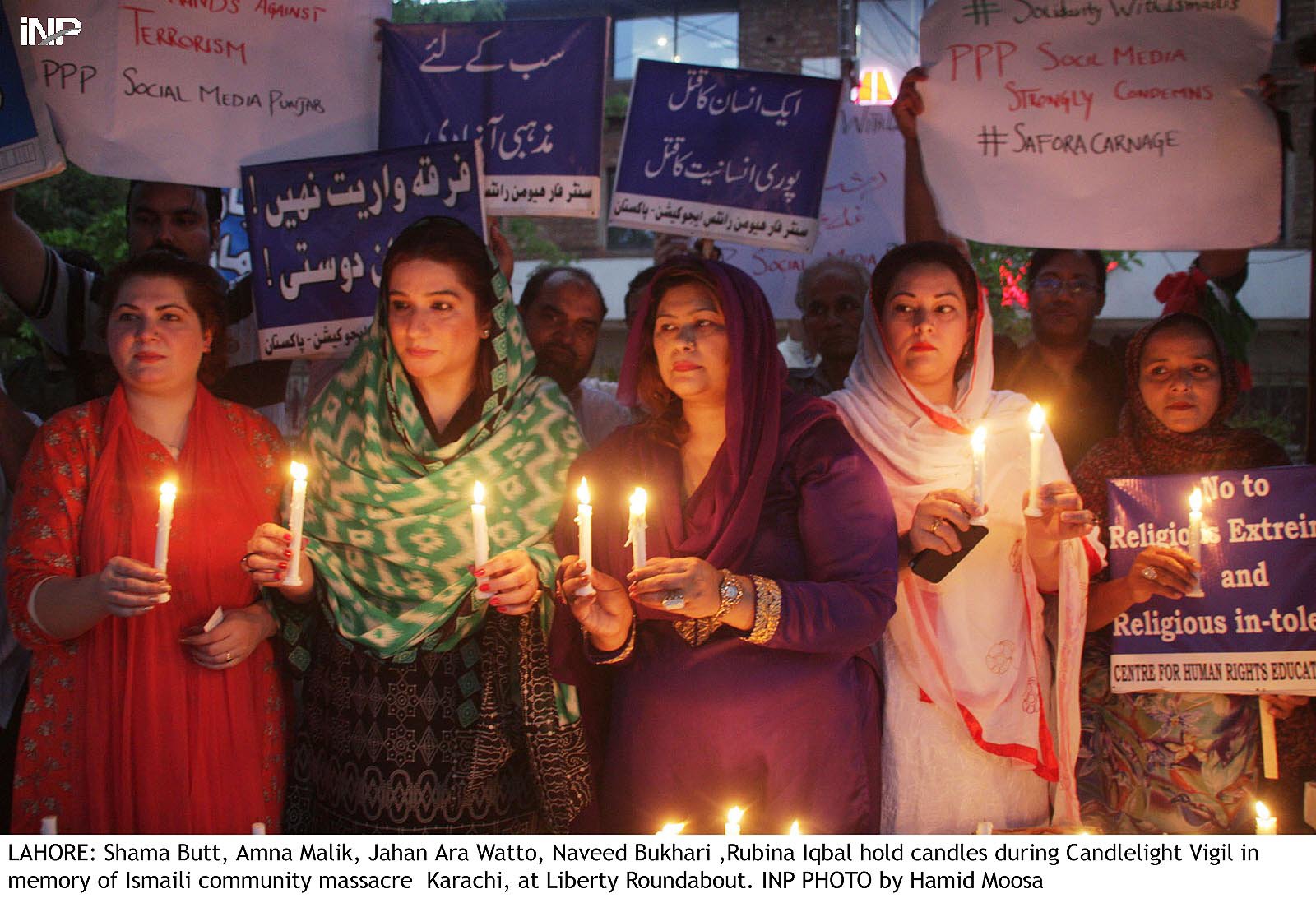 people hold candles during a candlelight bigil in memory of the victims of the karachi massacre at liberty roundabaout photo inp