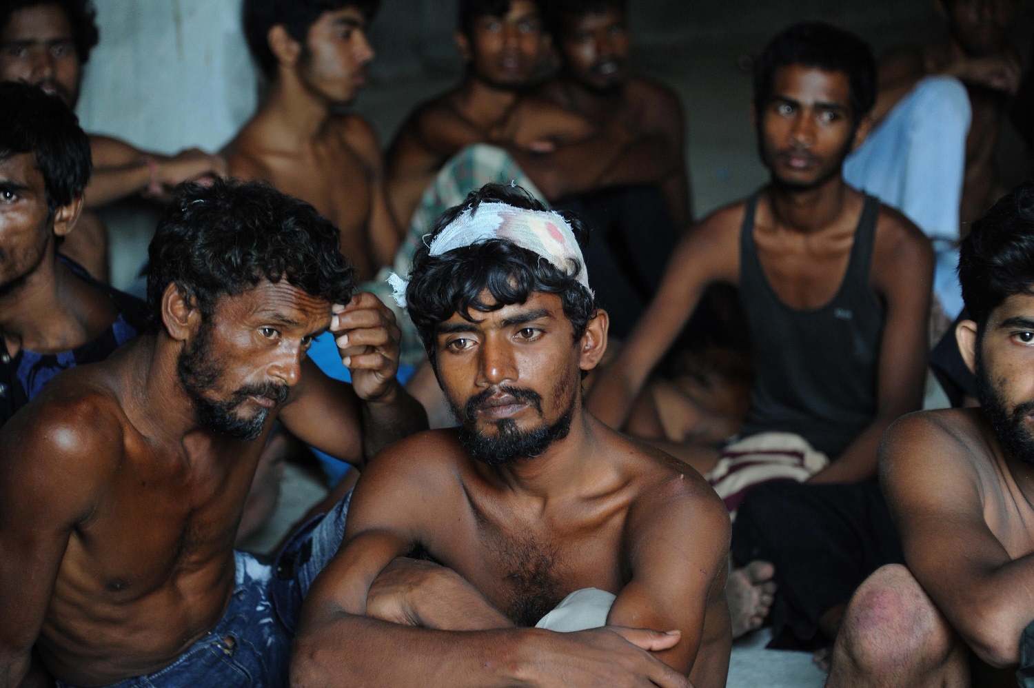 a group of rescued migrants mostly rohingya from myanmar and bangladesh rest on their arrival at the new confinement area in the fishing town of kuala langsa in aceh province on may 15 2015 photo afp