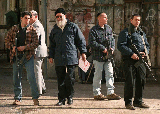 a picture taken on january 20 1996 shows rabbi moshe levinger c who founded the militant gush emunim movement which pushed jewish settlements in the west bank escorted by bodyguards in the west bank town of hebron to mark his presence as a protest against palestinian elections levinger died aged 80 on may 16 2015 relatives said photo afp