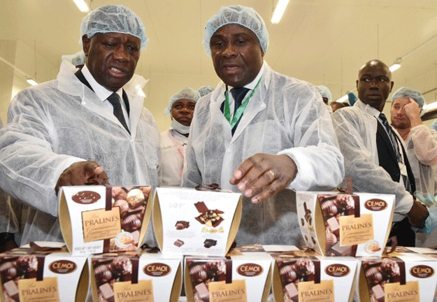 president of the ivory coast alassane ouattara l listens to benjamain bessie r the director general of the cemoi ivory coast c as he explains the production of chocolate during the inauguration of the french chocolate manufacturers cemoi factory in abidjan photo afp