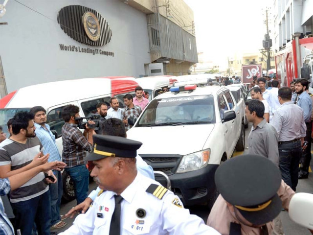 people gather around fia vehicles during a raid on the axact karachi office photo afp people gather around fia vehicles during a raid on the axact karachi office photo afp
