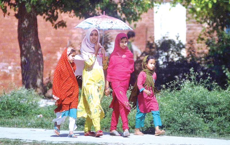 a group of young girls take cover of an umbrella in islamabad as temperature soars photo app