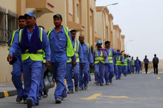 foreign labourers working on the construction site of the al wakrah football stadium walk back to their accomodation at the ezdan 40 compound after finishing work on may 4 2015 in doha photo afp