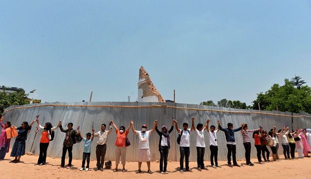 nepalese people hold hands as they stand around the collapsed dharahara tower in kathmandu on may 25 2015 as the country marks one month since a deadly earthquake struck the country killing more than 8 600 people the april 25 disaster was followed by another massive quake on may 12 which sent shockwaves through the himalayan nation as the twin tremors killed over 8 600 people and left thousands desperate for food shelter and clean water photo afp