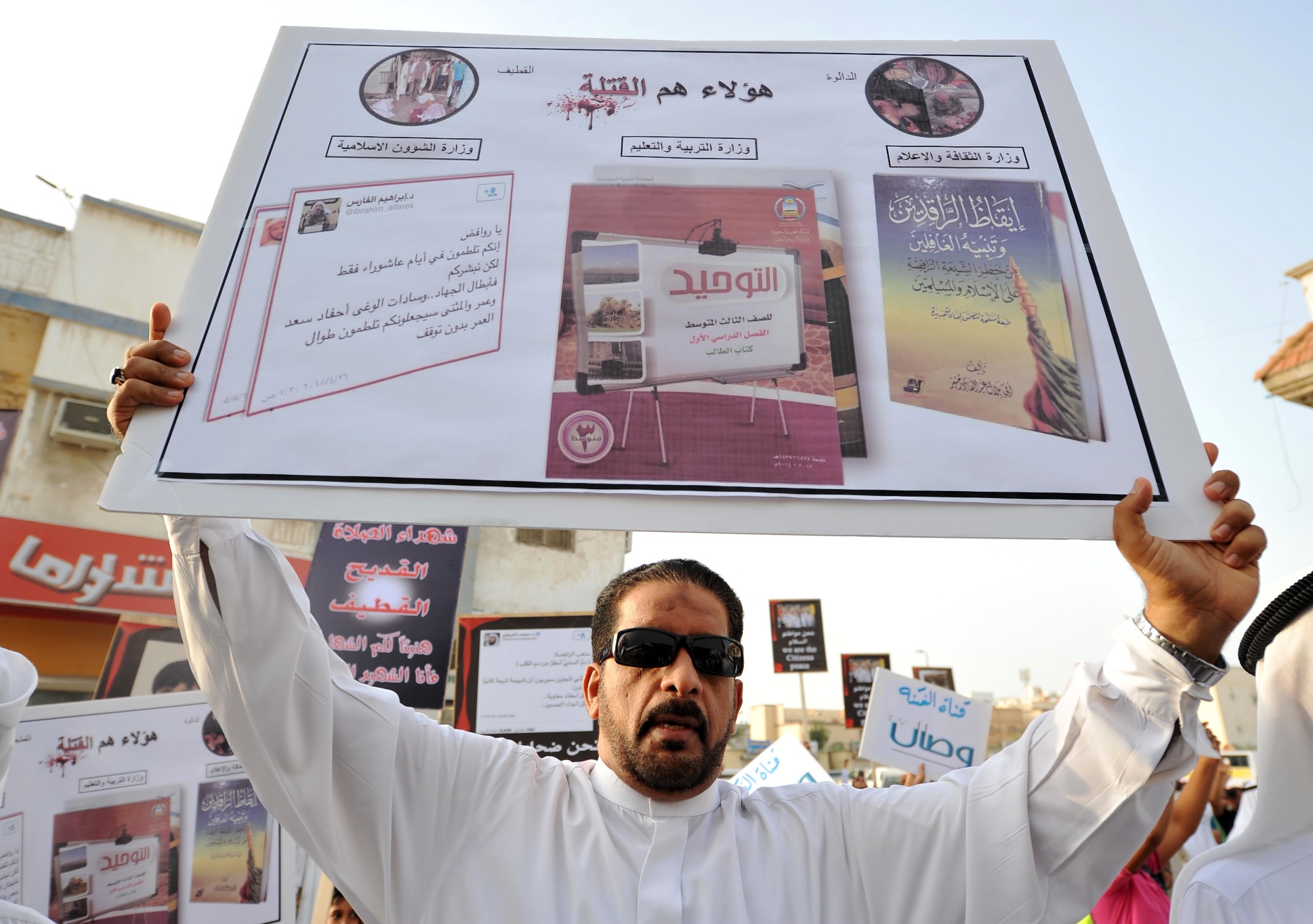 a saudi man holds a placard during a protest outside a mosque in kudeih in the mainly shia saudi gulf coastal town of qatif 400 kms east of riyadh on may 24 2015 photo afp