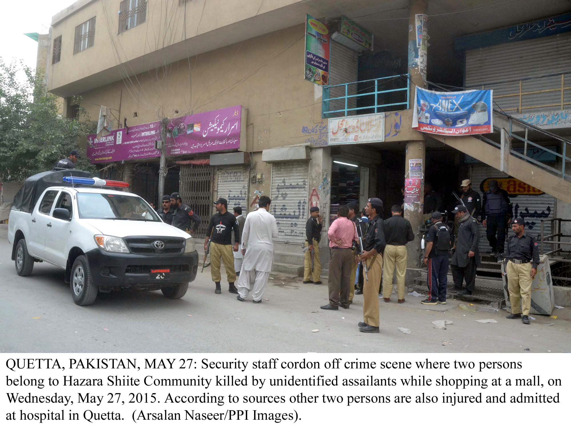 police officials gather outside the store where two hazara men were gunned down on wednesday photo ppi