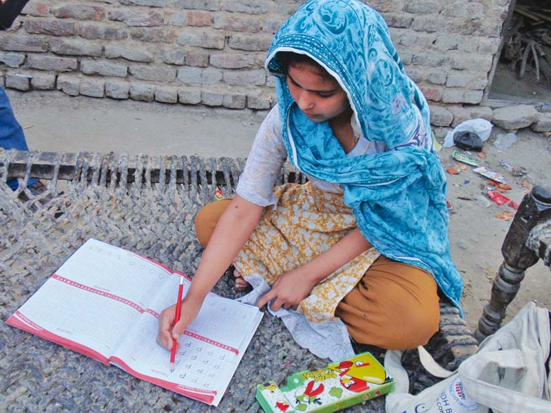 nine year old rukhsana manages to finish her homework in between the chores that she helps her mother with at four different houses in sukkur photo express