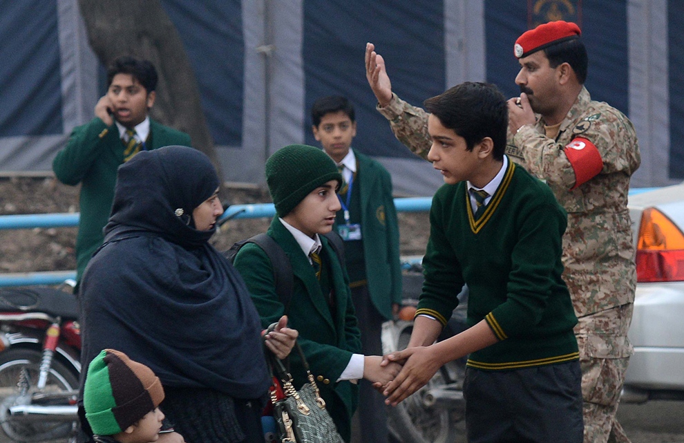 a mother drops her children amid heightened security at the army public school in peshawar on january 12 2015 photo afp