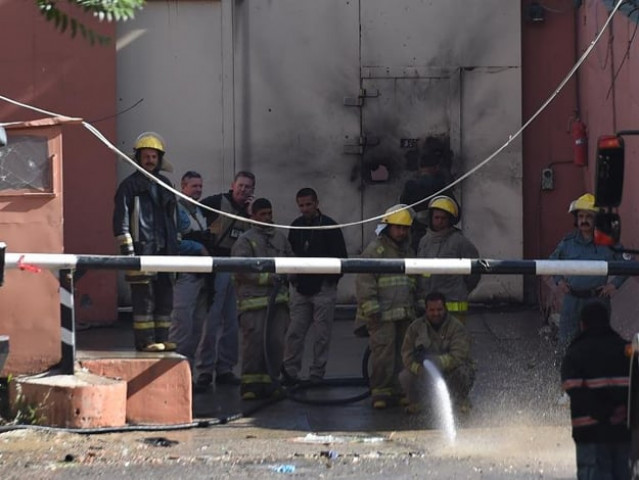 afghan firefighters spray water in front of the gates of the heetal hotel in kabul photo afp afghan firefighters spray water in front of the gates of the heetal hotel in kabul photo afp