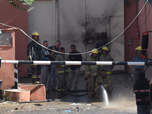 afghan firefighters spray water in front of the gates of the heetal hotel in kabul photo afp