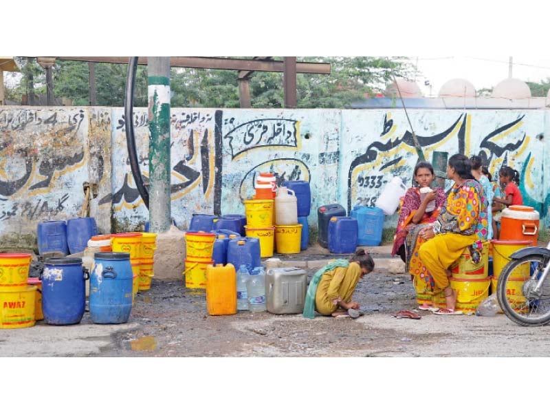 women wait with their containers to fill them with water karachi has been suffering from an acute water crisis for over a month forcing citizens to wait in long queues to collect water photo mohammad noman express