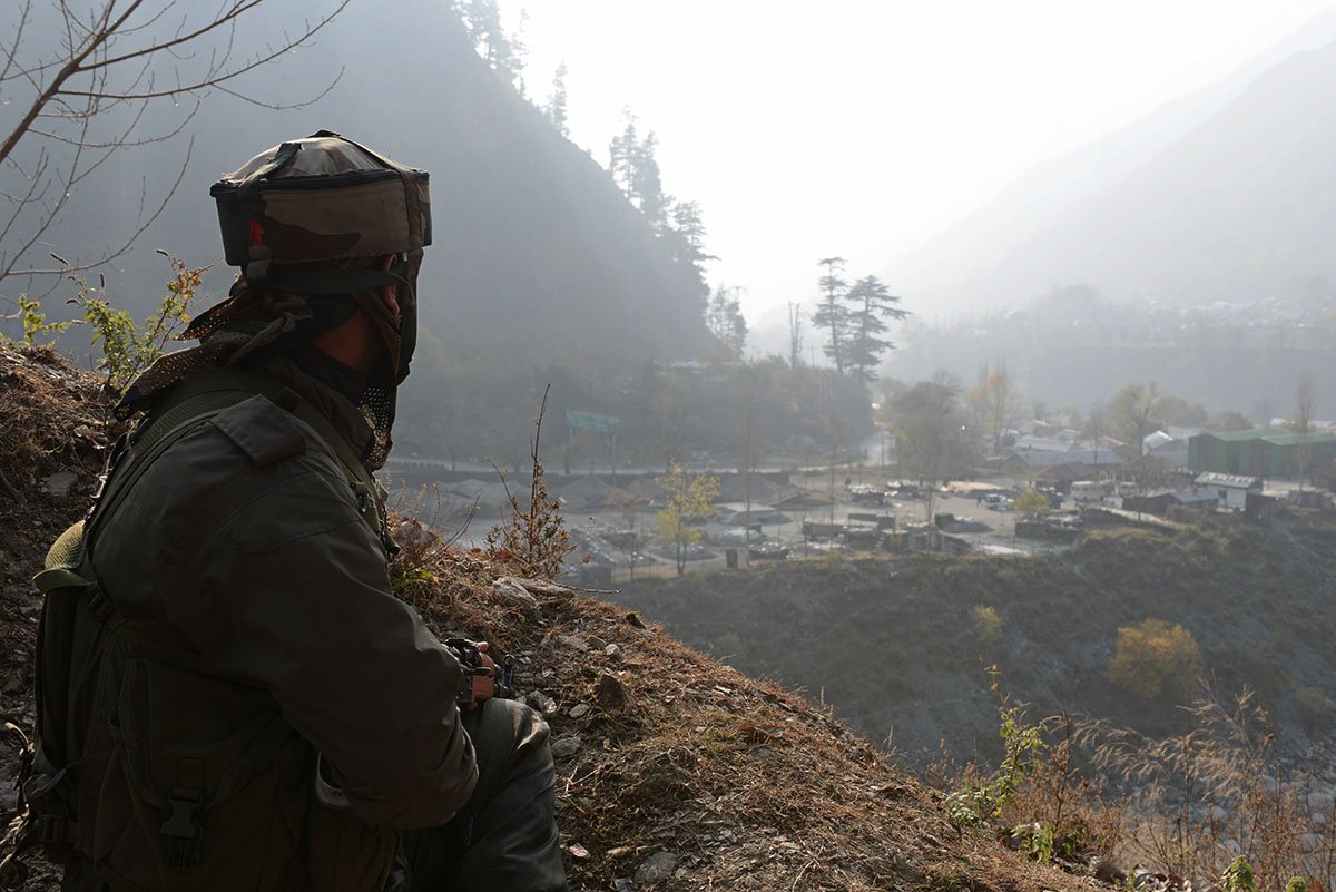an indian soldier keeps watch from his position overlooking army barracks near the line of control loc photo afp