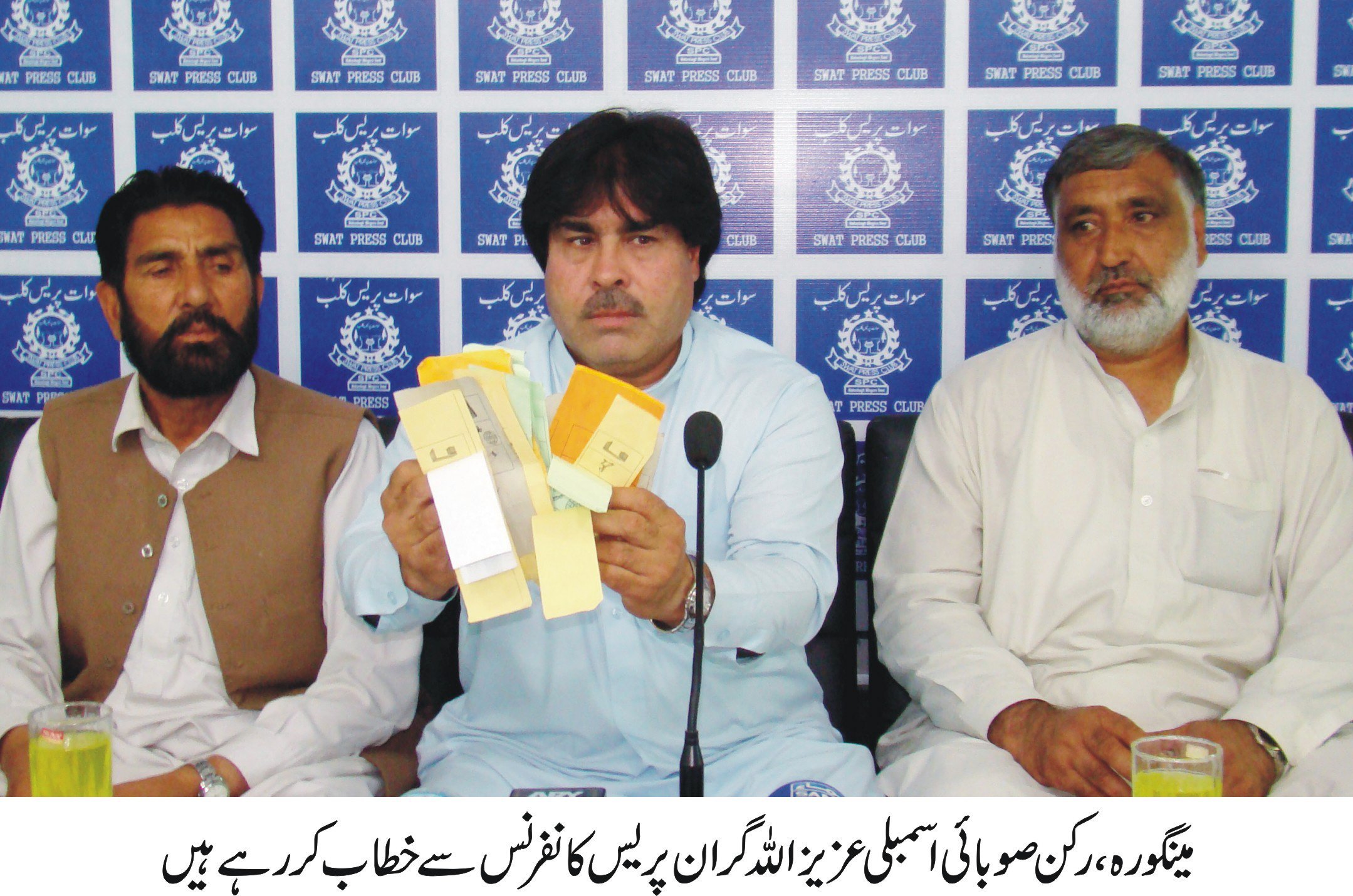 minister k p assembly showing torn ballot papers at a press conference at the peshawar press club photo express