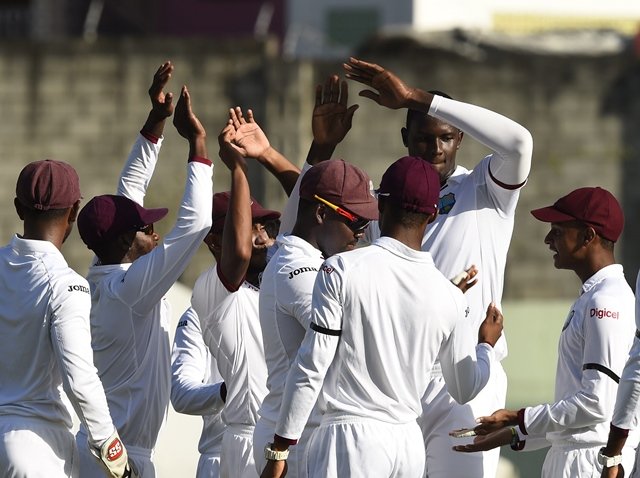 west indies bowler jason holde celebrates with teammates after australia 039 s shaun marsh is out on a catch by west indies darren bravo on the first day of the first cricket test match between australia and the west indies june 3 2015 at windsor park stadium in roseau dominica photo afp