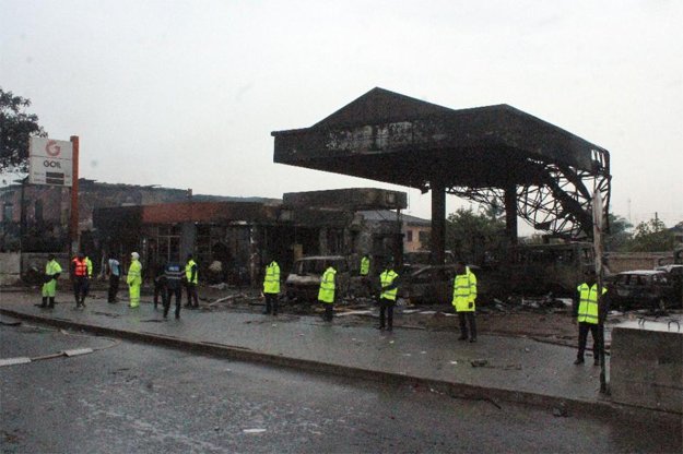 policemen stand guard as rescuers work on the site where at least 90 people were killed in a petrol station fire in accra photo afp