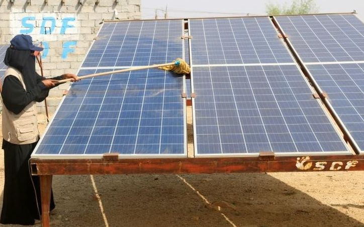 a yemeni woman cleans a solar panel at the friends of the environment station photo afp