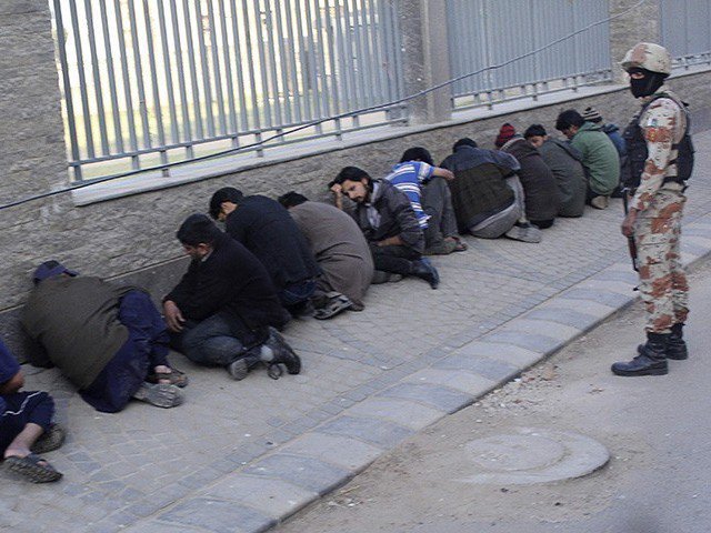 a paramilitary soldier stands beside detained supporters during a raid on muttahida qaumi movement mqm political party 039 s headquarters in karachi on march 11 2015 photo reuters