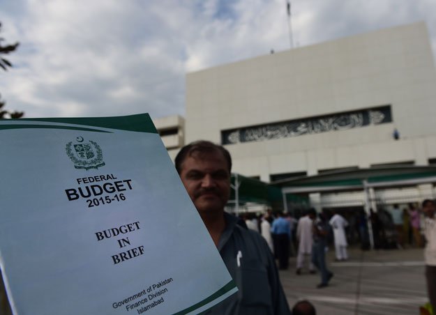a man poses with a copy of the country 039 s budget report outside the parliament building during the annual budget session in islamabad on june 5 2015 photo afp