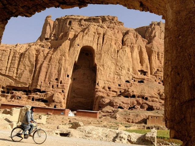 an afghan man rids his bicycle in front of the empty seat of the buddha destroyed by the taliban photo afp an afghan man rids his bicycle in front of the empty seat of the buddha destroyed by the taliban photo afp