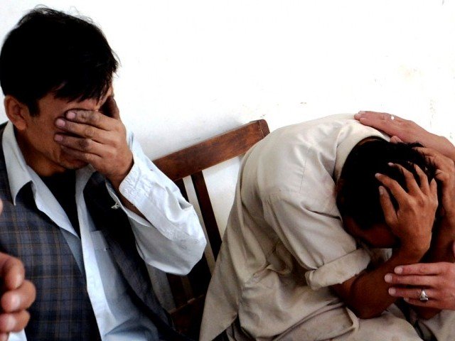 a file photo of relatives mourning after gunmen riding motorcycle opened fire on tyre shop located in quetta photo afp