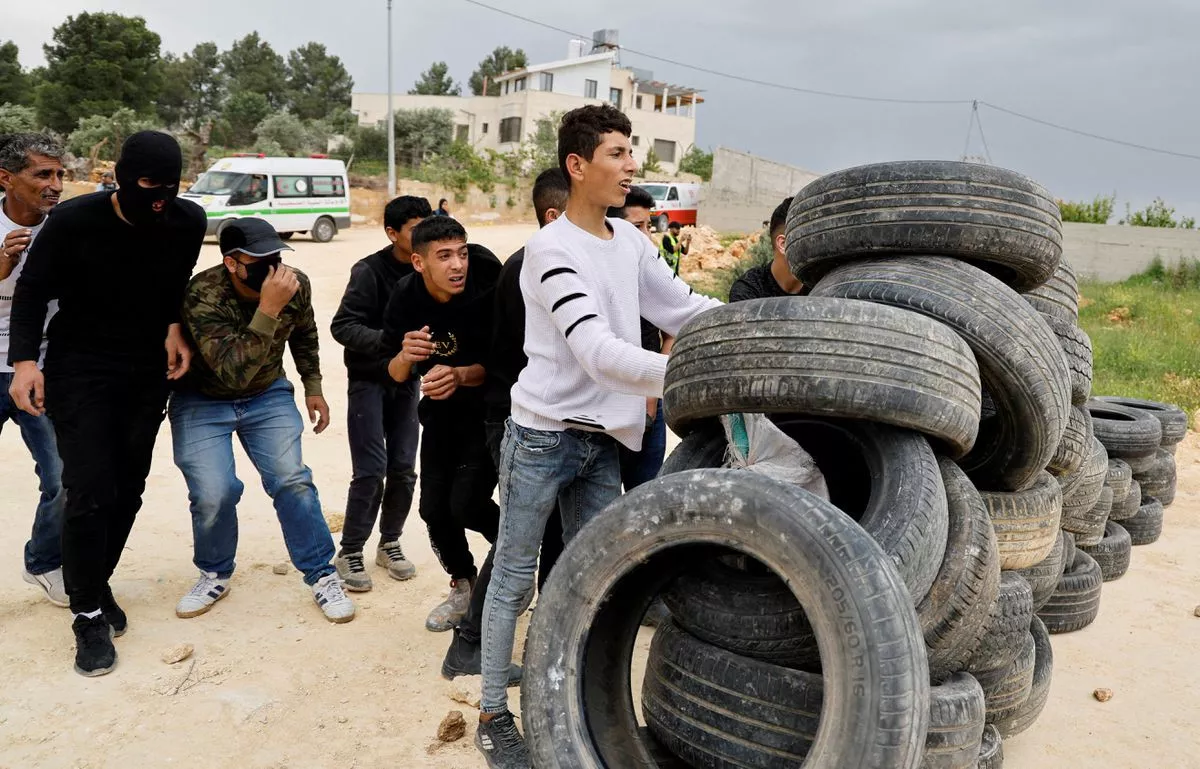 palestinian demonstrators take cover behind tires during a protest against israeli settlements near nablus in the israeli occupied west bank april 10 2023 photo reuters palestinian demonstrators take cover behind tires during a protest against israeli settlements near nablus in the israeli occupied west bank april 10 2023 photo reuters