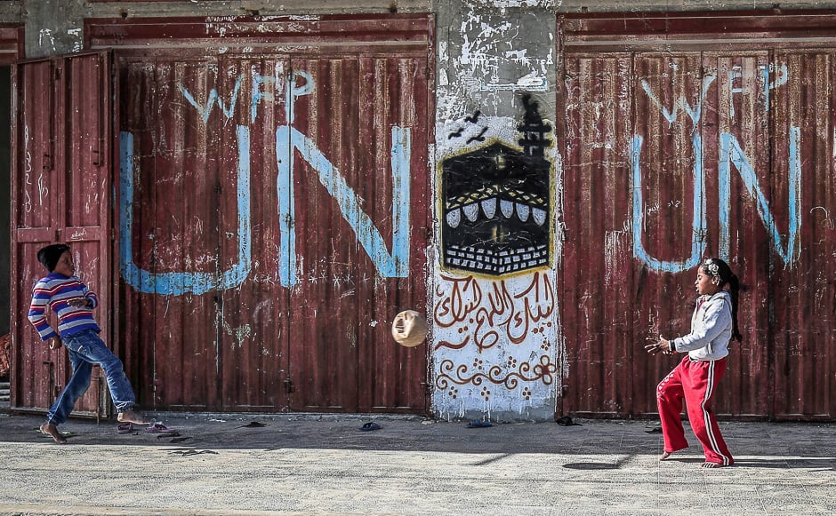 Palestinian children play with a ball outside a UN food distribution warehouse at the Rafah refugee camp in the southern Gaza strip. PHOTO: AFP