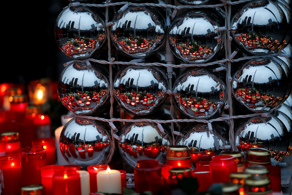 Candles are refected in Christmas tree balls at the Christmas market in Berlin, Germany one day after a truck ploughed into a crowded Christmas market in the German capital. PHOTO: REUTERS