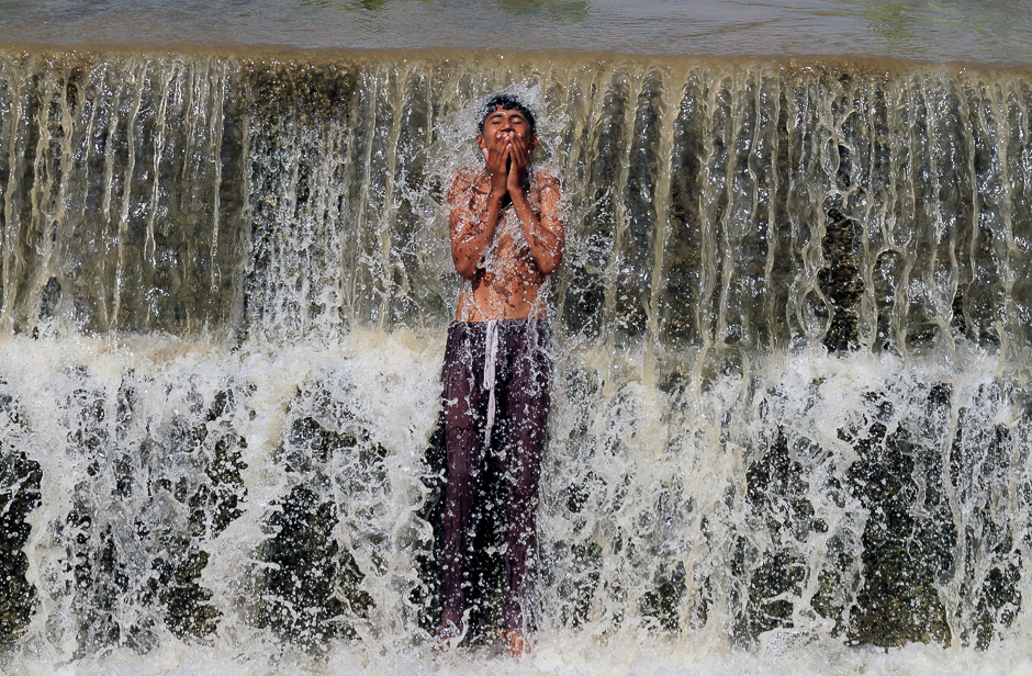a boy bathes in a stream to cool off from the heat on a hot summer day in swabi pakistan photo reuters
