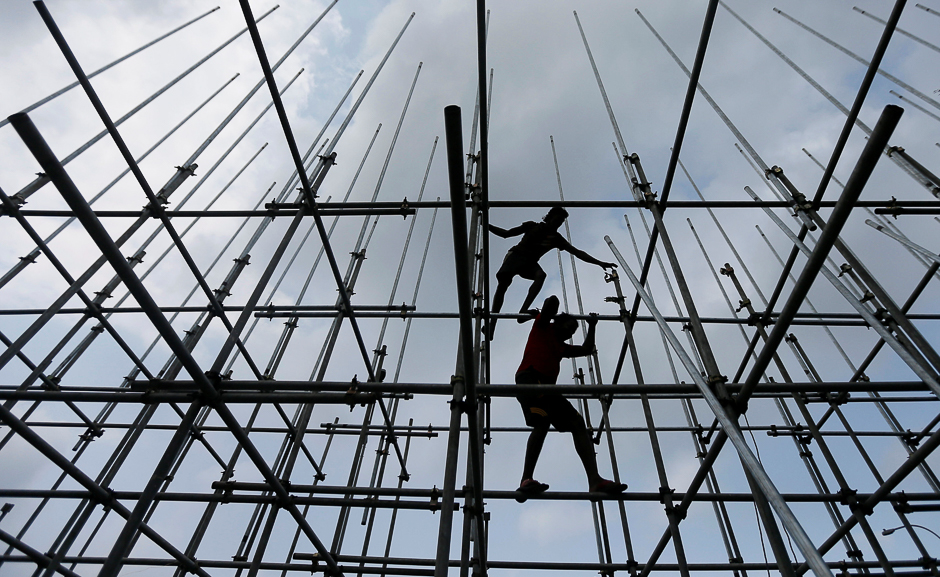Two men walk on a pandal, a temporary platform to be decorated with illuminated panels illustrating episodes from the life of Buddha, as they fix it ahead of Vesak Day celebrations in Colombo, Sri Lanka. PHOTO: REUTERS