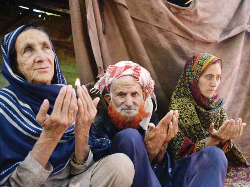 the parents of pakistani kashmiri convicted killer shafqat hussain pray as they sit with relatives in muzaffarabad photo afp