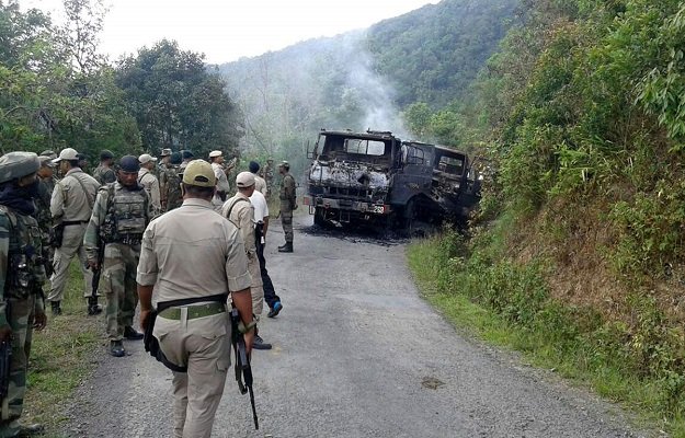 in this photograph taken on june 4 2015 indian security personnel stand alongside the smouldering vehicle wreckage at the scene of an attack on a military convoy in a remote area of chandel district about 120 kilometres 75 miles southwest of northeastern manipur 039 s state capital imphal photo afp